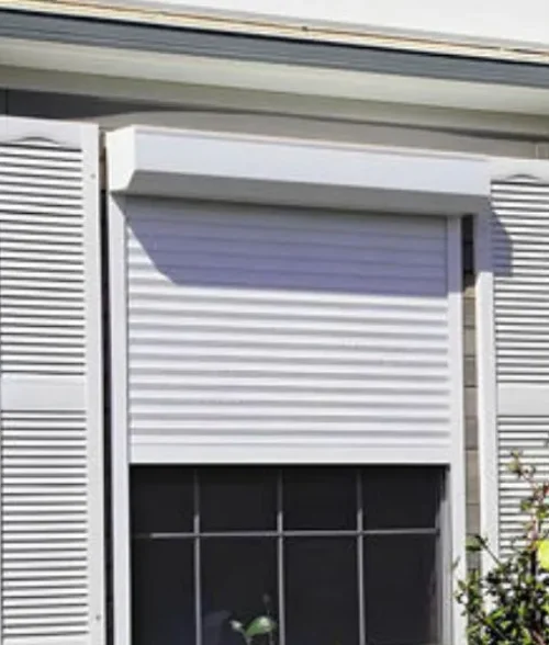 Powder-coated white aluminium shutters for window privacy and weather protection.